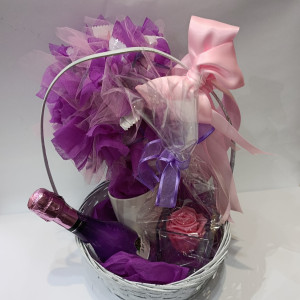 Poklon set sadrži elegantnu košaru s malom bocom šampanjca, dehidriranom ružom u staklenoj vazi i dekorativnim buketom drvca izrađenim od slatkiša u ljubičastim nijansama. Posebnost seta je personalizirana šalica na koju je moguće ručno napisati ime ili poruku, a natpis ostaje postojan i nakon pranja. Ovaj unikatni poklon set savršen je za rođendane, godišnjice, darivanje voljenih osoba ili posebne prigode.